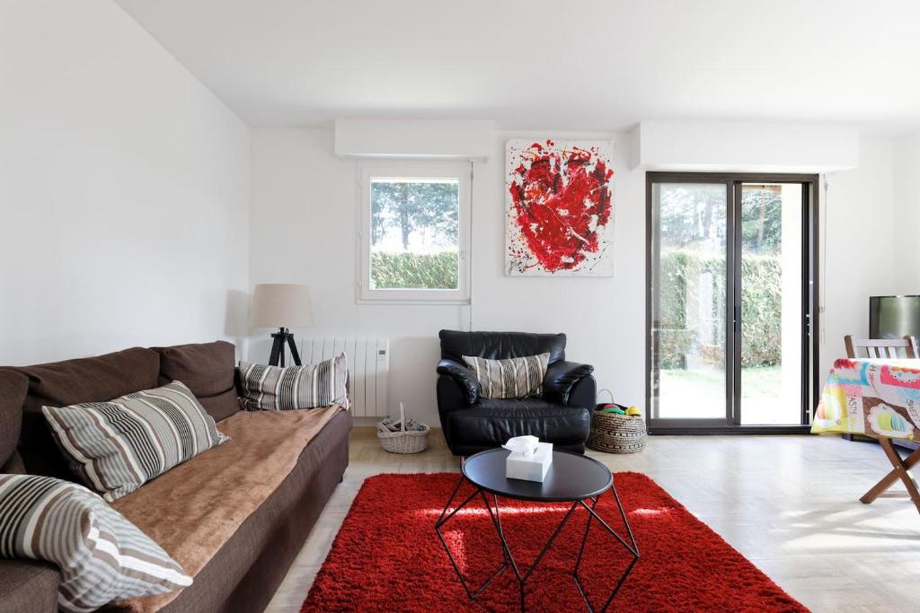 un salon avec un canapé et un tapis rouge dans l'établissement Charmant 3 pièces avec jardin à 5mn de la plage, à Deauville