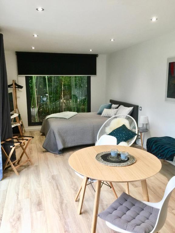 une chambre avec un lit, une table et des chaises dans l'établissement Un petit nid dans la verdure, à Holtzwihr