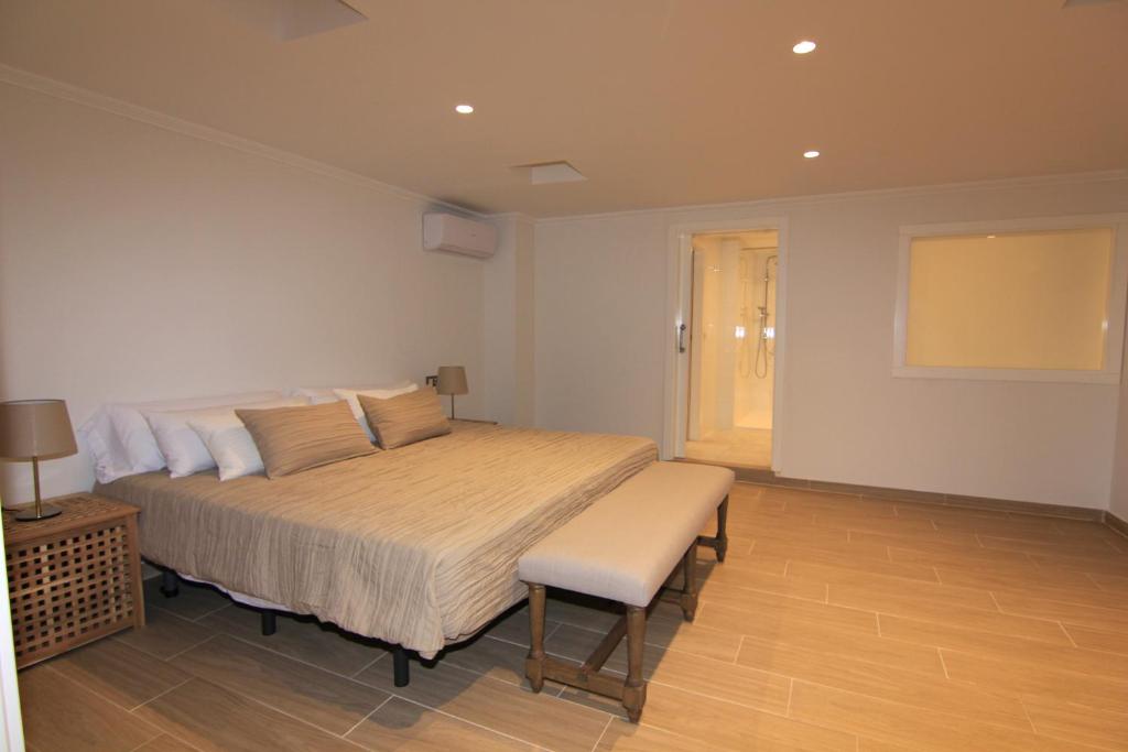 a bedroom with a large bed and a chair at Orly Club Coral Arena Dorada in Puerto del Carmen