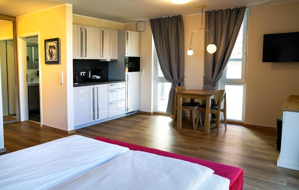 Cet appartement comprend une chambre avec un lit et une cuisine avec une table. dans l'établissement Boardinghouse City Home, à Bielefeld