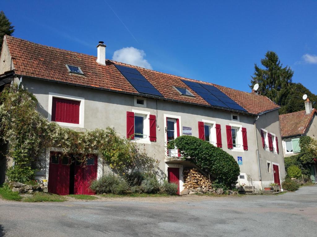 a white house with red doors and red windows at Chambres d`hôtes Le Plessis in Broye