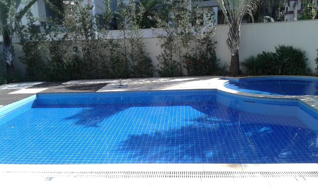 ein Pool mit blauen Fliesen im Hof in der Unterkunft condominio palmeiras in Ubatuba