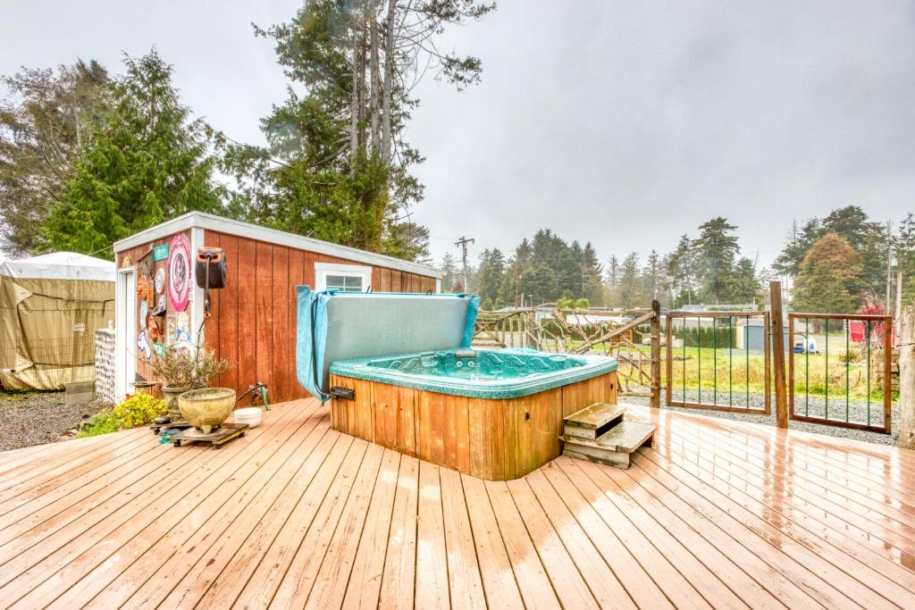 una bañera de hidromasaje en una terraza de madera con una casa en Getaway Bar on Easy Street, en Rockaway Beach