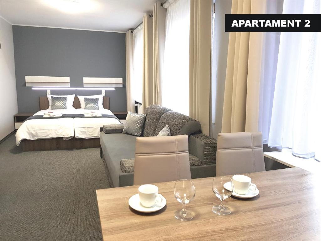 a room with a bed and a table with glasses on it at Kamienica Grand Starówka in Elblag