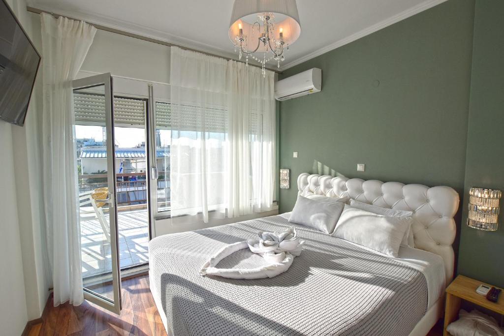a bedroom with a large bed with a large window at John's Hotel in Chalkida