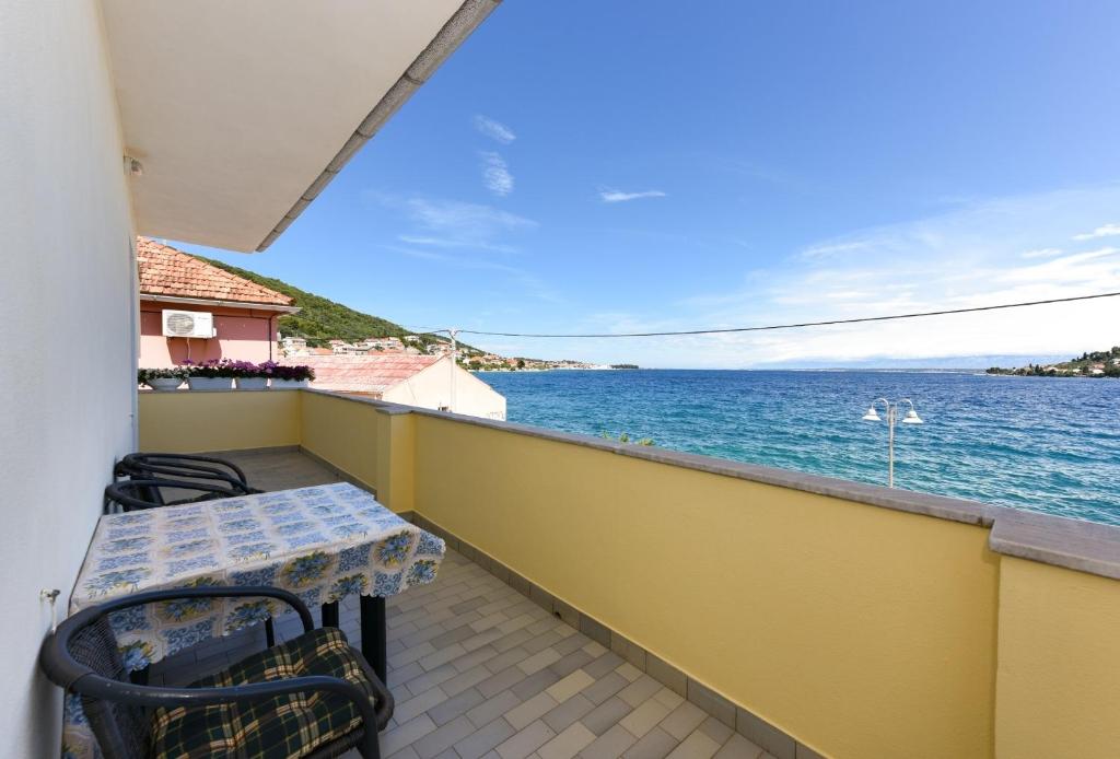 d'un balcon avec une table et des chaises donnant sur l'eau. dans l'établissement Apartments Kolt - 15m from sea, à Kali