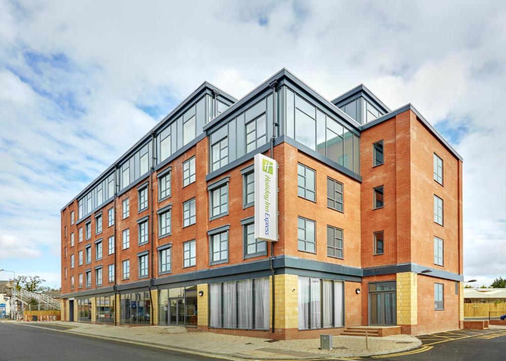 グリムズビーにあるHoliday Inn Express Grimsby, an IHG Hotelの通り面のガラス窓のあるレンガ造りの建物