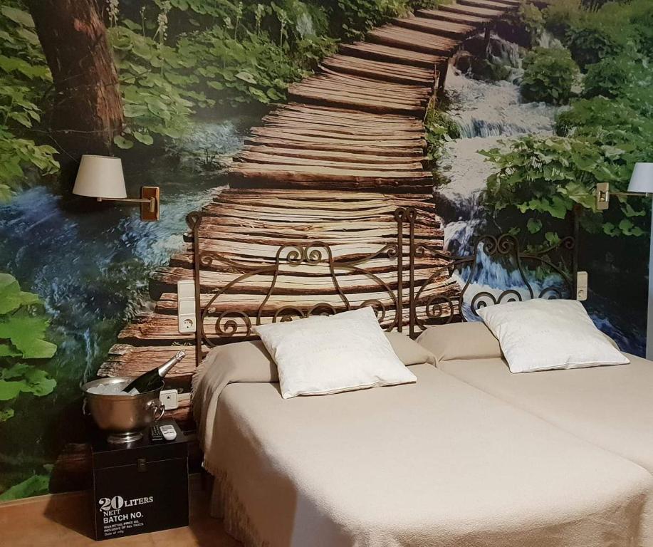 een slaapkamer met een bed en een schilderij van een houten brug bij Hotel Iris La Eliana in La Eliana