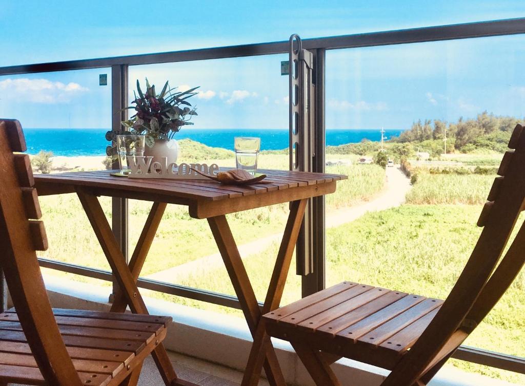 a table and chairs on a balcony with a view of the ocean at Ocean Resort Maeda / Vacation STAY 3223 in Onna