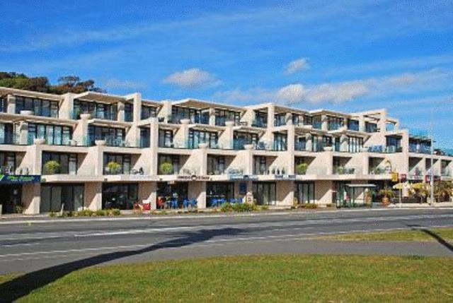 a large white building on the side of a street at The Sands in Nelson