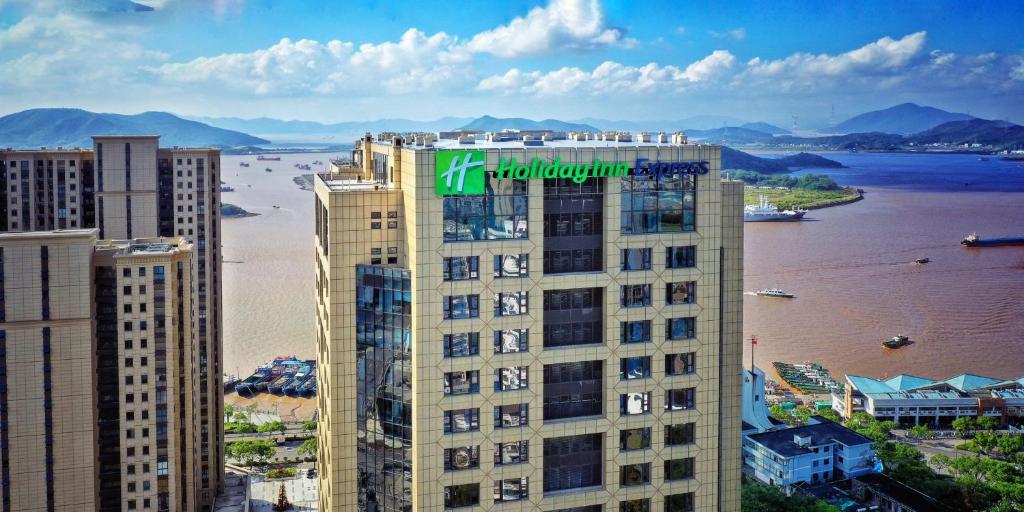 un edificio alto con un cartel en la parte superior en Holiday Inn Express Zhoushan Dinghai, an IHG Hotel en Zhoushan