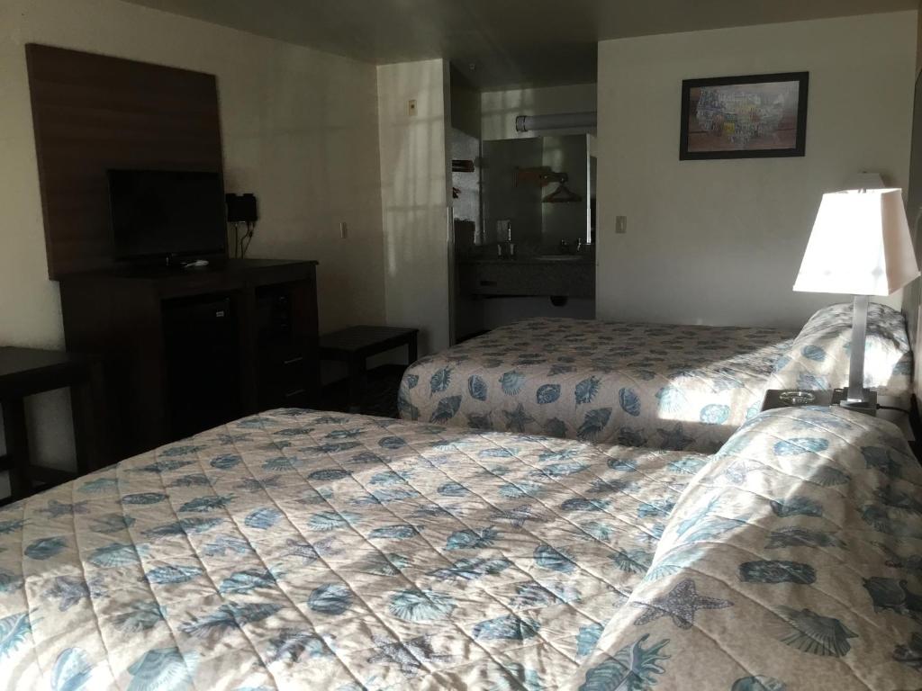 a hotel room with two beds and a television at Executive Inn westley,CA in Westley