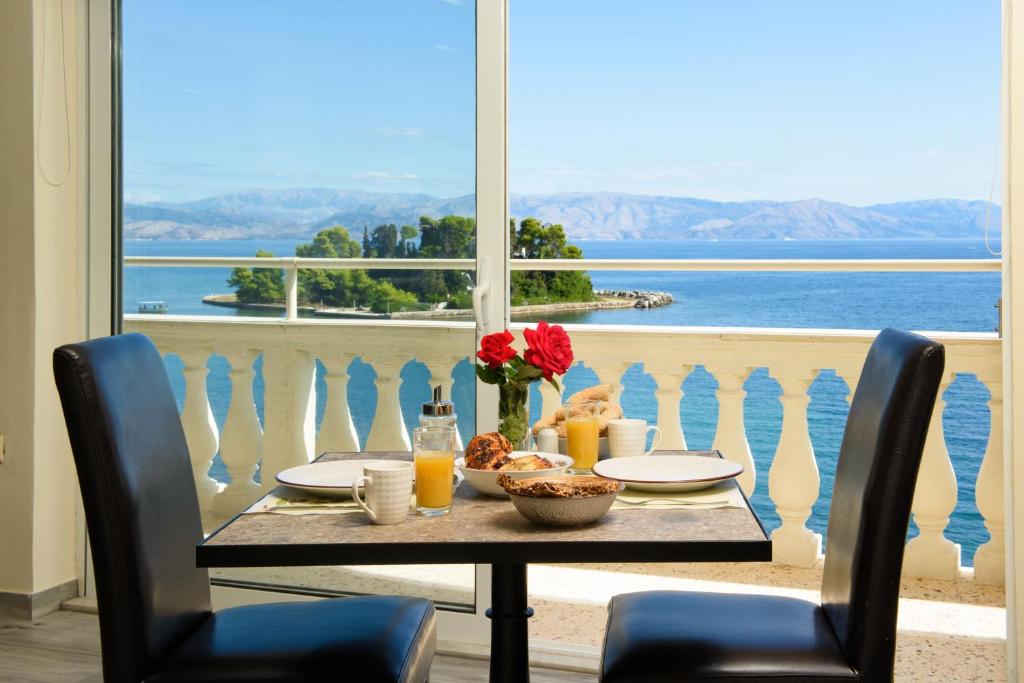 una mesa con comida y vistas al océano en Pontikonisi Hotel & Suites, en Perama