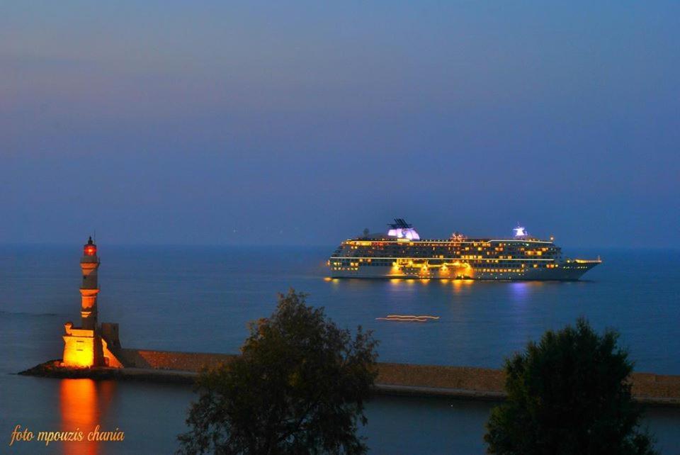 a cruise ship in the water with a lighthouse at Rooms 47 in Chania Town