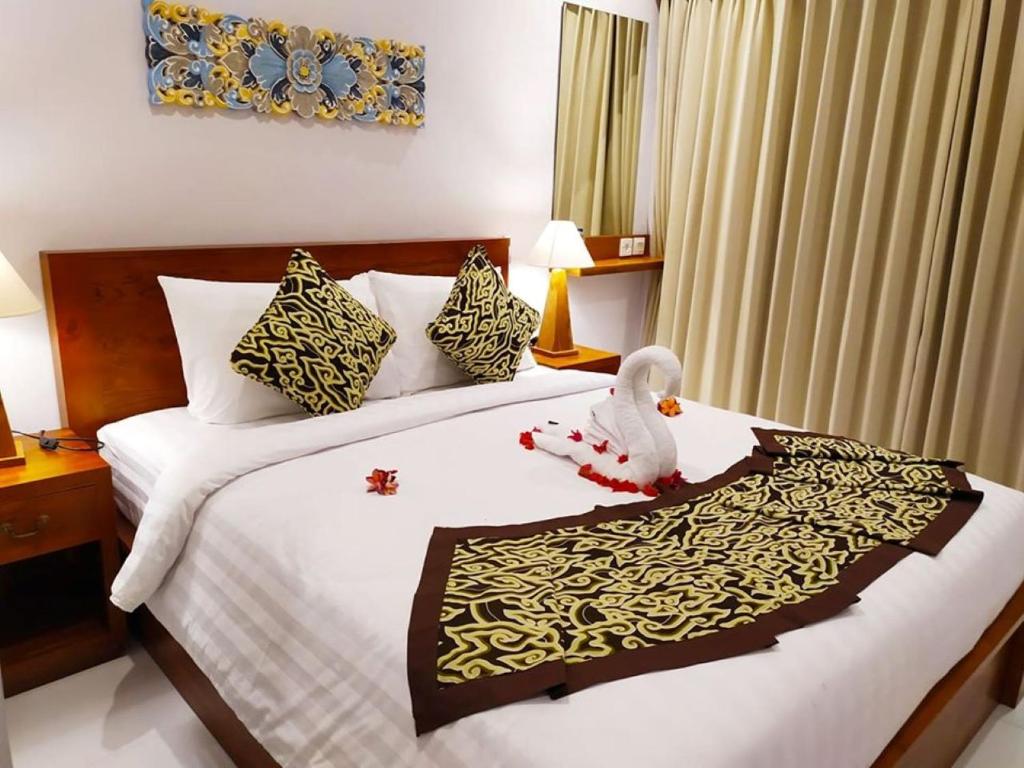 um quarto com uma cama com um bicho de peluche em BatanTop Ubud guest house em Ubud