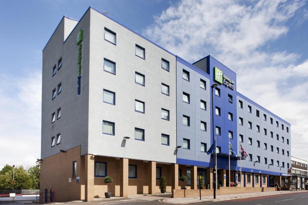 a large white building on the corner of a street at Holiday Inn Express Park Royal, an IHG Hotel in London