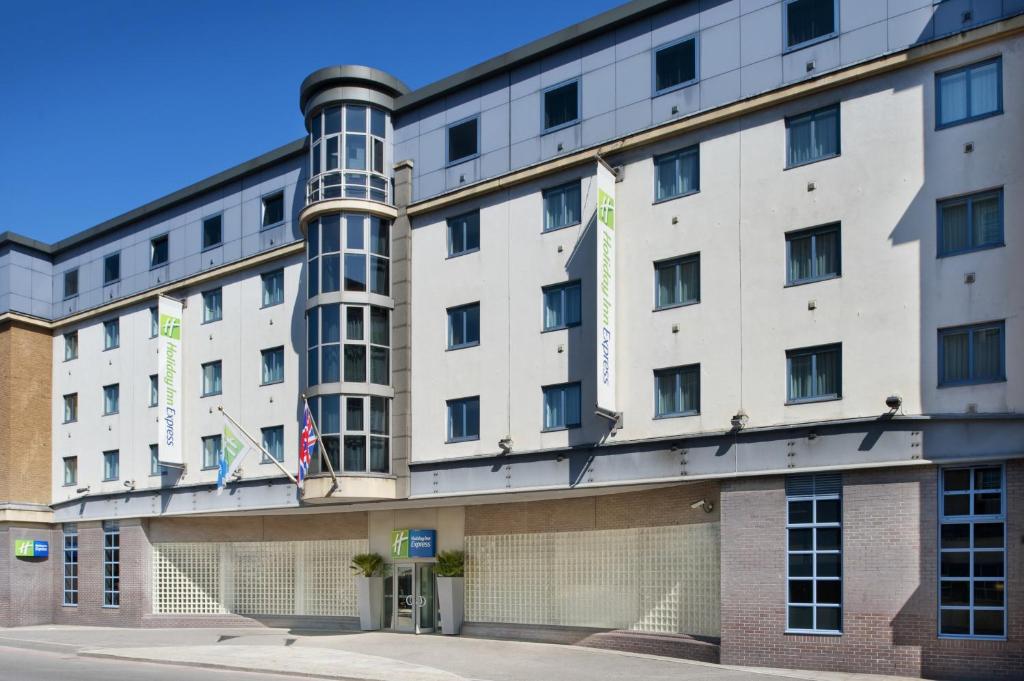 un gran edificio blanco con banderas. en Holiday Inn Express London City, an IHG Hotel, en Londres