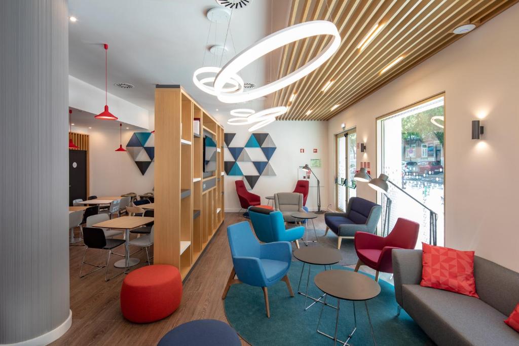 a waiting area in a hospital with chairs and tables at Holiday Inn Express - Lisbon - Plaza Saldanha, an IHG Hotel in Lisbon