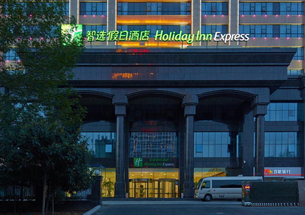 un edificio con una furgoneta estacionada frente a él en Holiday Inn Express Luoyang City Center, an IHG Hotel, en Luoyang