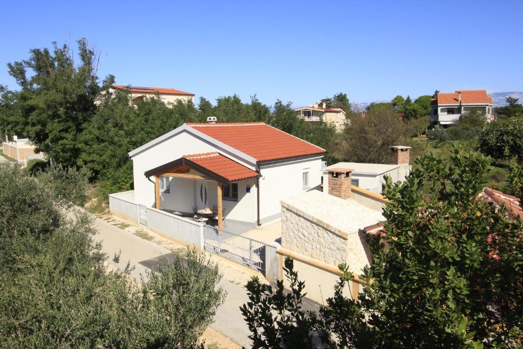 une maison blanche avec un toit rouge dans l'établissement Holiday home Olive, à Privlaka