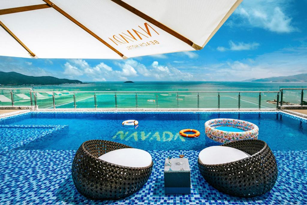 a swimming pool with a view of the ocean at Navada Beach Hotel in Nha Trang