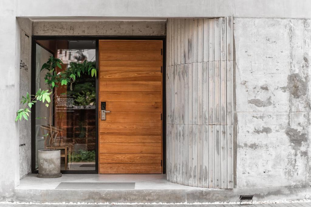 een houten deur aan de zijkant van een gebouw bij The Earth Hotel in Chiang Mai