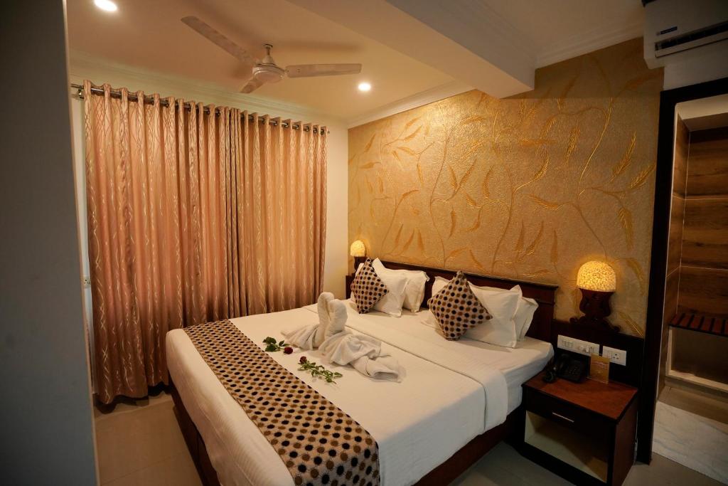 una camera da letto con un grande letto con lenzuola bianche di Kallelys Park Inn, Chalakudy ,Thrissur a Kizhake Chālakudi