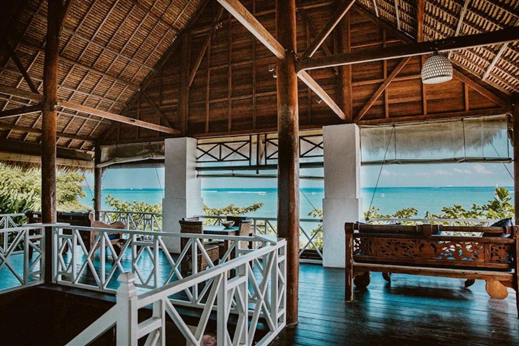 Zimmer mit einem Balkon mit einer Bank und Meerblick in der Unterkunft Kainalu Beach House in Nusa Lembongan