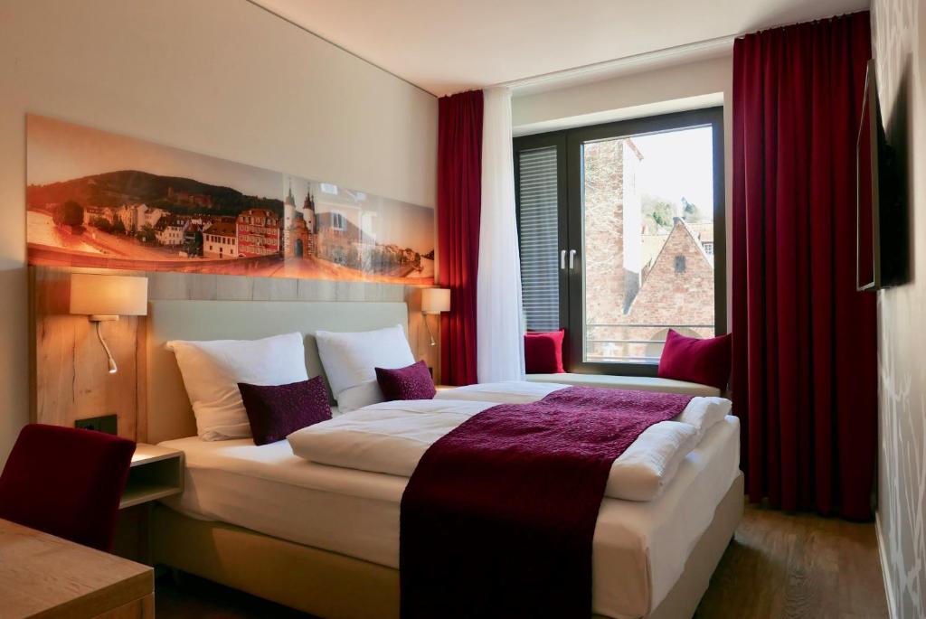 a hotel room with two beds and a window at Rafaela Hotel Heidelberg in Heidelberg