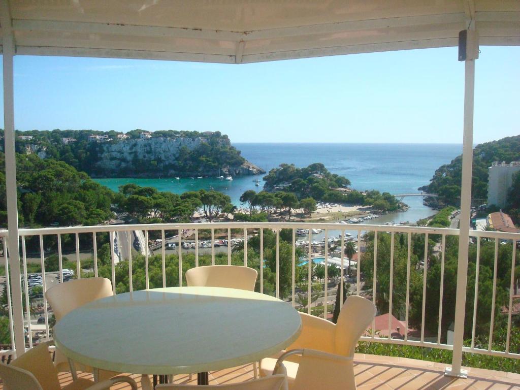 un tavolo e sedie su un balcone con vista sull'oceano di Menorca Bonavista a Cala Galdana