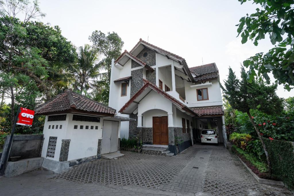 una casa blanca con una señal roja delante de ella en SUPER OYO 1778 Omah Duwet en Yogyakarta
