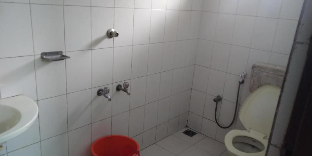a bathroom with a toilet and a sink at UNNIKRISHNA LODGE in Cochin