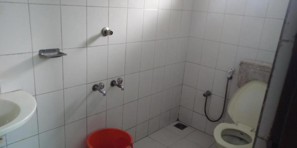 y baño con aseo y lavamanos. en UNNIKRISHNA LODGE, en Kochi