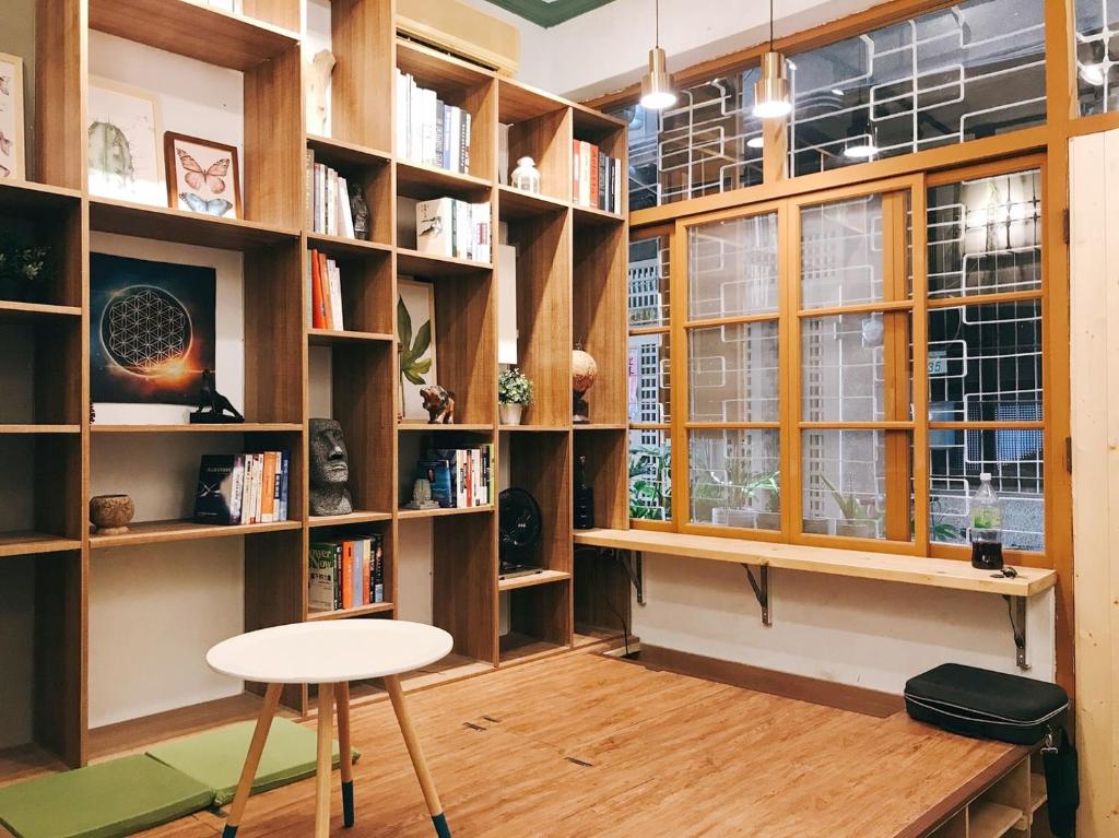 a library with wooden shelves and a table and a stool at 醒覺旅人-訂房後需聯繫轉帳 in Tainan