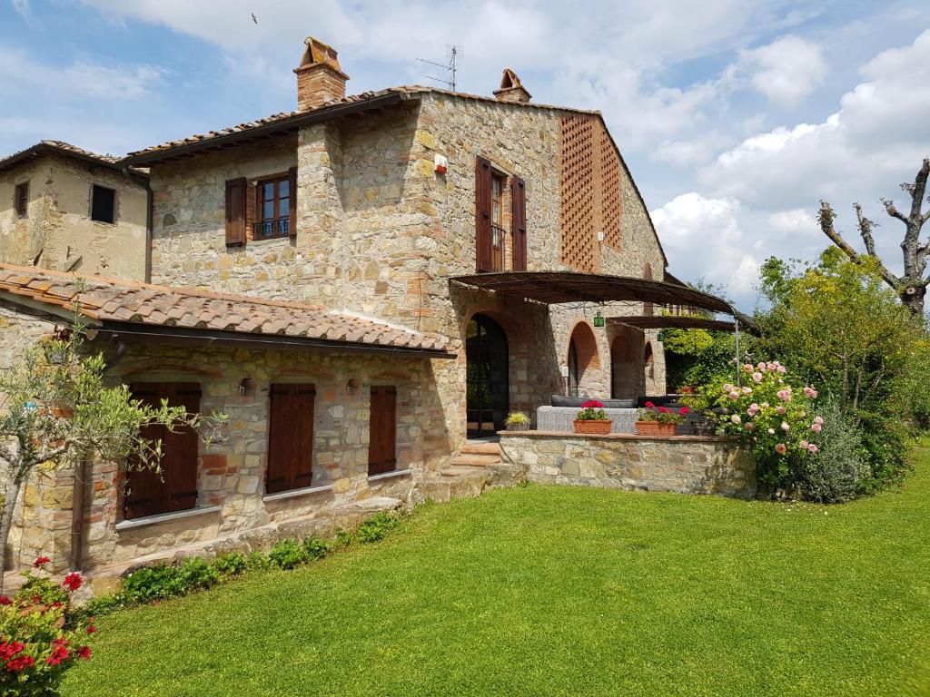 uma antiga casa de pedra com um jardim de relva em La Casa di Manuela, Villa Indipendente nel Chianti con Vasca Idromassaggio em Barberino di Val dʼElsa