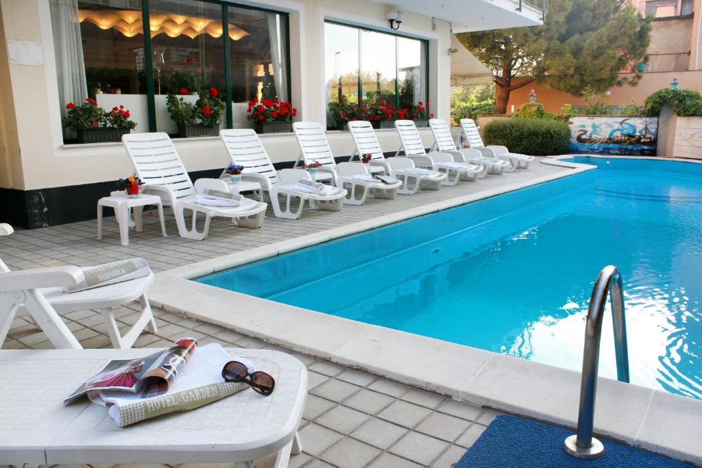 - un groupe de chaises et une piscine dans l'établissement Hotel Garden, à Albissola Marina