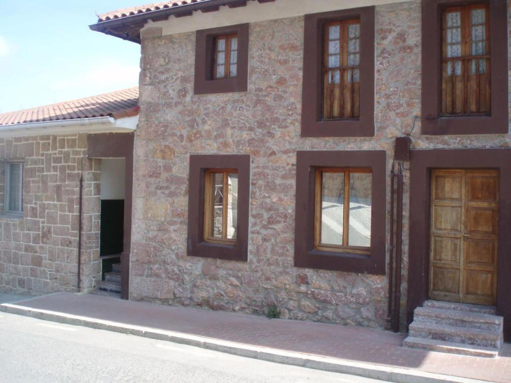 uma casa de tijolos com portas de madeira numa rua em Casa en Urdaibai para disfrutar la zona E-BI00235 em Elejalde
