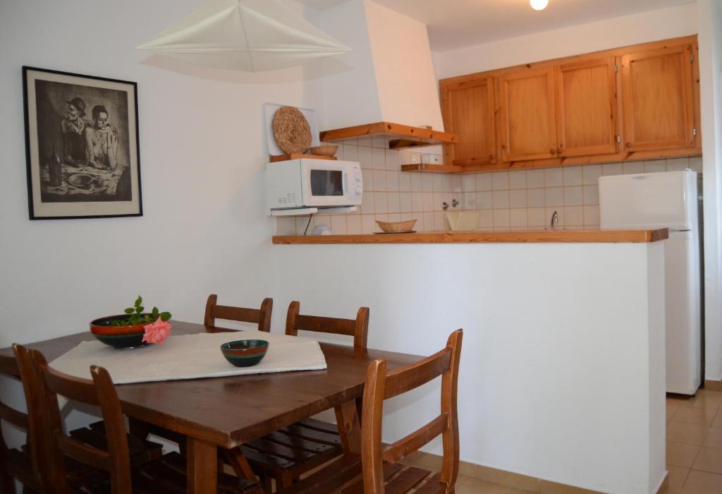a kitchen with a table with chairs and a microwave at Menorca Bonavista in Cala Galdana