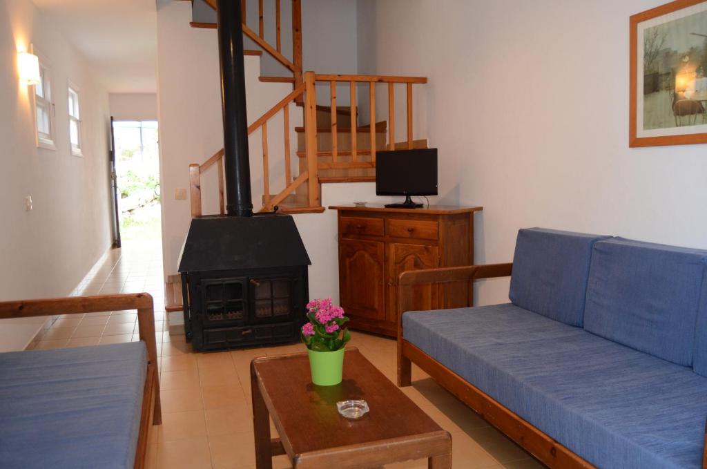a living room with a blue couch and a fireplace at Menorca Bonavista in Cala Galdana
