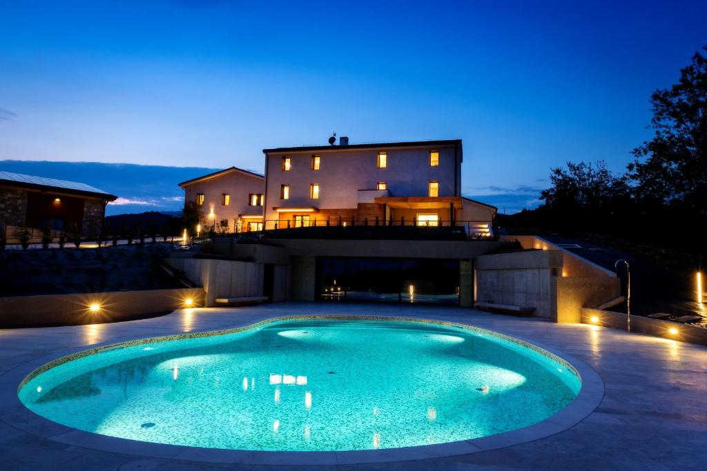 una piscina di fronte a una casa di notte di Relais Althea Azienda Agrituristica a Vittorio Veneto