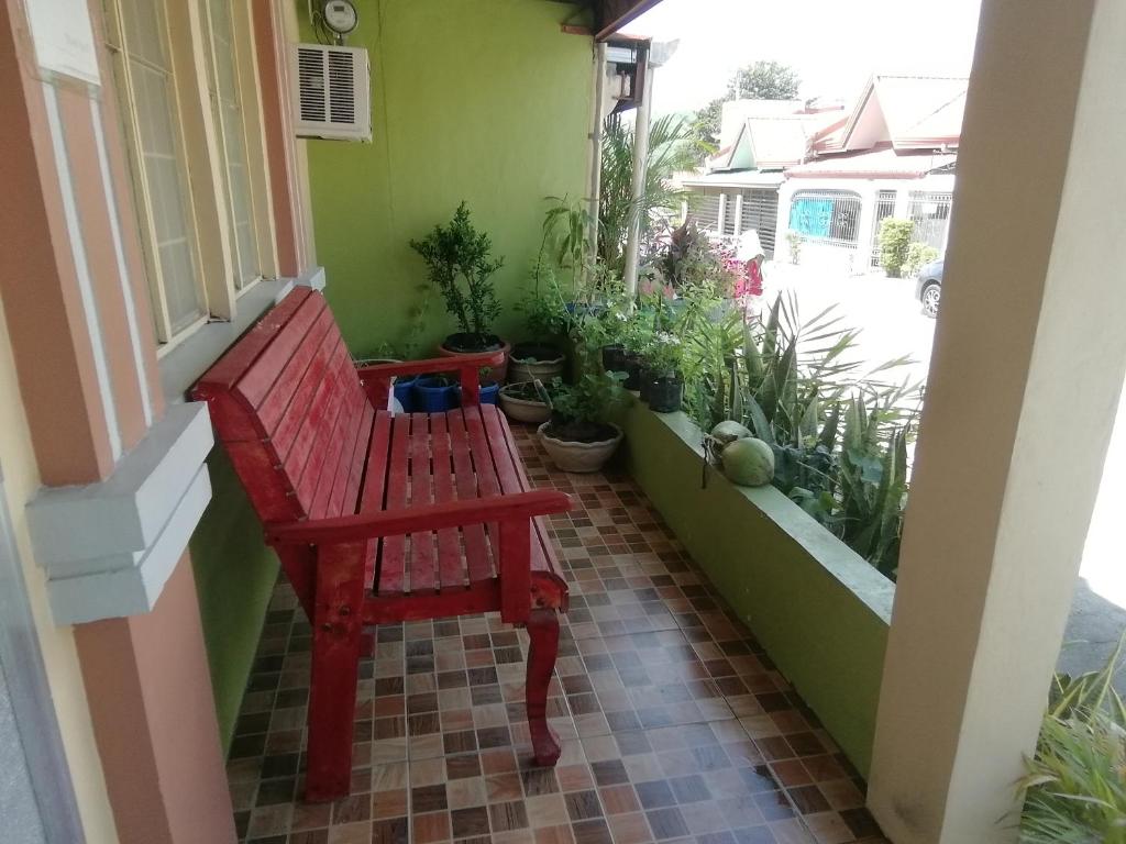 a red bench sitting on the side of a window at Laly's B8 cozy Vacation Townhouse - 10km to SBMA in Olongapo