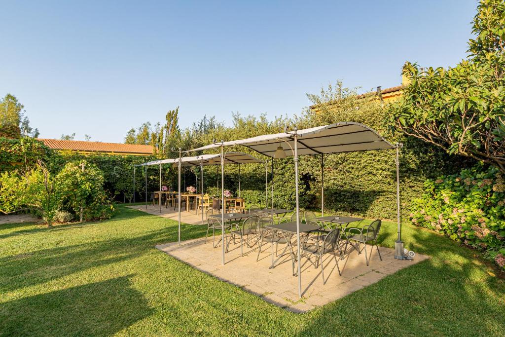 a patio with tables and chairs under umbrellas at Wine Resort Ledà d'Ittiri in Fertilia