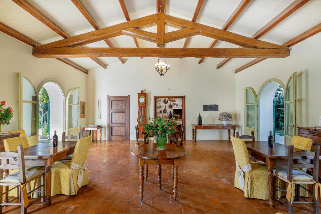 a dining room with wooden ceilings and a table and chairs at Wine Resort Ledà d'Ittiri in Fertilia