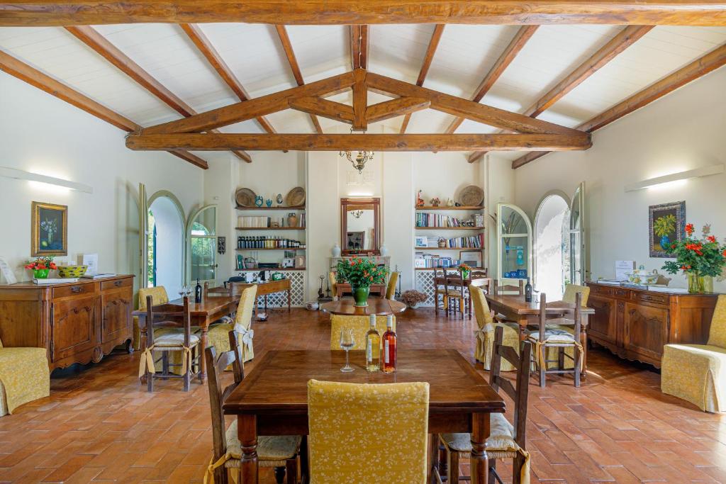 a dining room with wooden tables and chairs at Wine Resort Ledà d'Ittiri in Fertilia