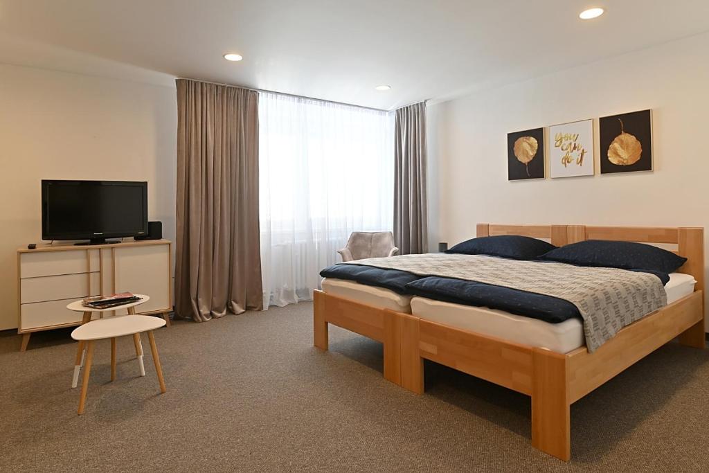 sypialnia z łóżkiem i telewizorem w pokoju w obiekcie Apartmán 5FIVE w Preszowie
