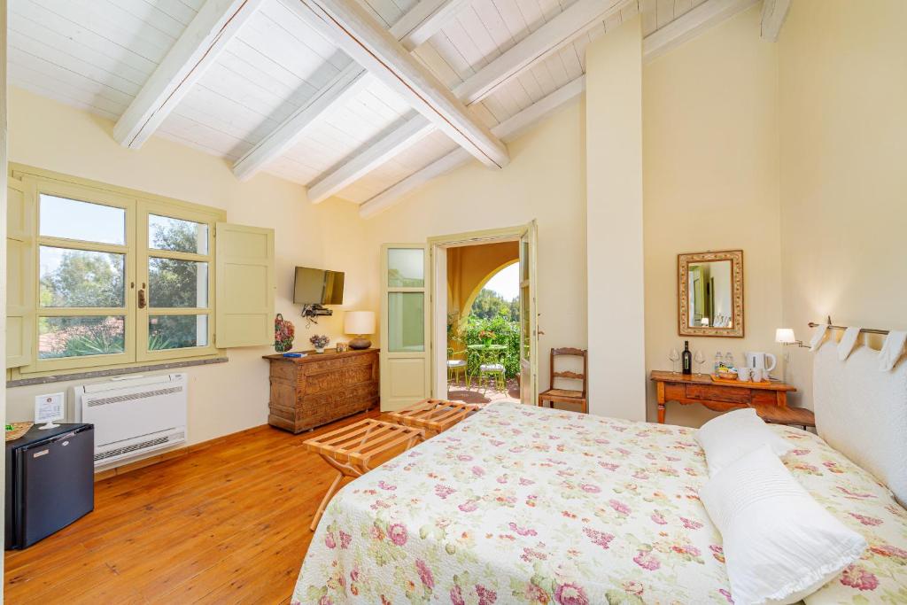 a bedroom with a large bed and a window at Wine Resort Ledà d'Ittiri in Fertilia