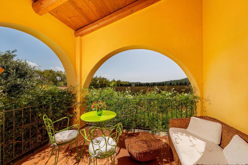 a patio with a table and chairs on a balcony at Wine Resort Ledà d'Ittiri in Fertilia