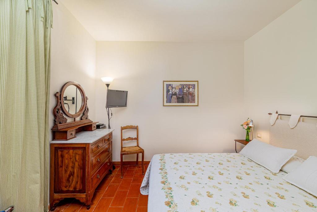 a bedroom with a bed and a mirror and a dresser at Wine Resort Ledà d'Ittiri in Fertilia