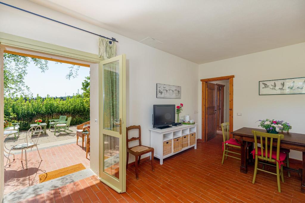 a living room with a television and a table and chairs at Wine Resort Ledà d'Ittiri in Fertilia