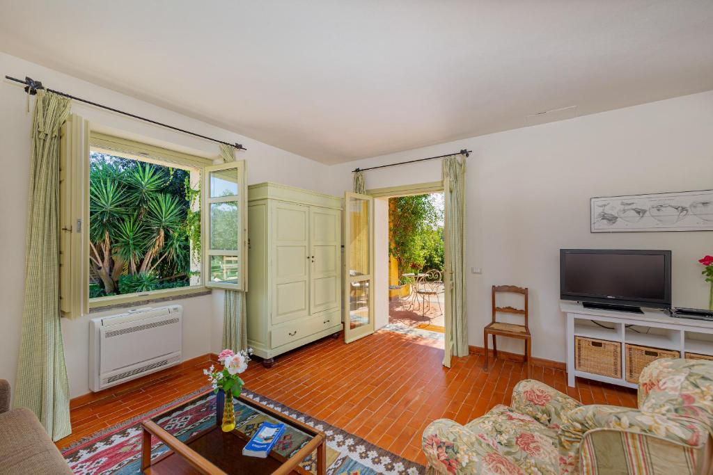 a living room with a couch and a television at Wine Resort Ledà d'Ittiri in Fertilia